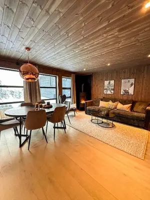 a living room with a table and a couch at Norebu - Norefjell in Noresund