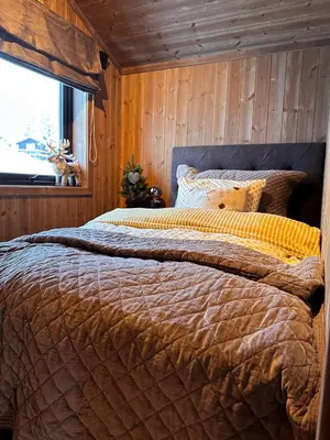 a bedroom with a large bed with a window at Norebu - Norefjell in Noresund