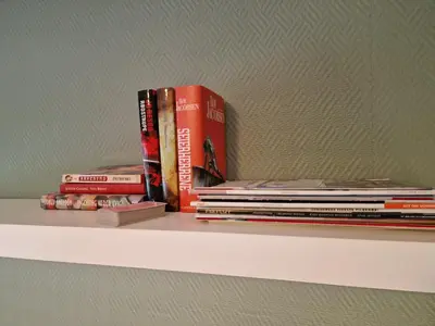 a stack of books sitting on a shelf at Rom 4 i bufellesskap in Sogndal