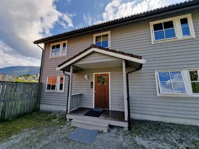 a house with a wooden door and a porch at Rom 4 i bufellesskap in Sogndal
