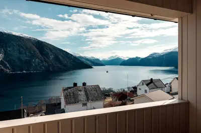a window with a view of a lake and mountains at Fjord Panorama in Stranda