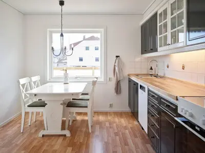 a kitchen with a white table and chairs and a window at Fjord Panorama in Stranda