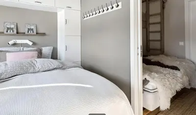 a bedroom with a white bed and a mirror at Geilo sentrum for 4 personer in Geilo