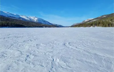 a frozen lake with snow covered mountains in the background at Gorgeous Apartment In Espedalen in Espedalen