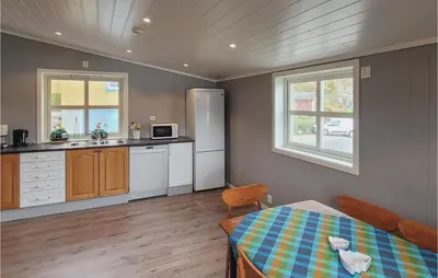 a kitchen with a table and a refrigerator at Beautiful Home In Vallavik With Kitchen in Djønno