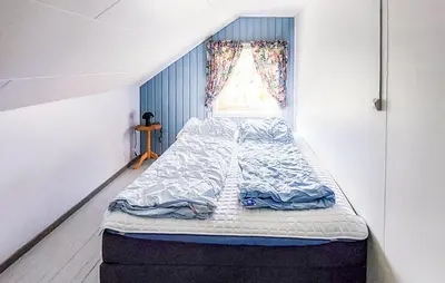 a large bed in a room with a window at Beautiful Home In Vallavik With Kitchen in Djønno