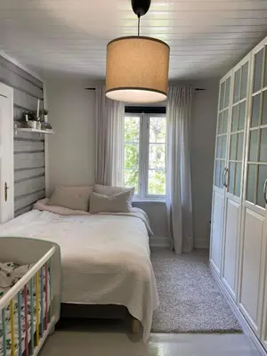 a bedroom with a bed and a large window at Sandstad, Lilleby i Trondheim in Trondheim