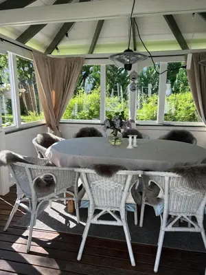 a dining room with a table and chairs and windows at Sandstad, Lilleby i Trondheim in Trondheim