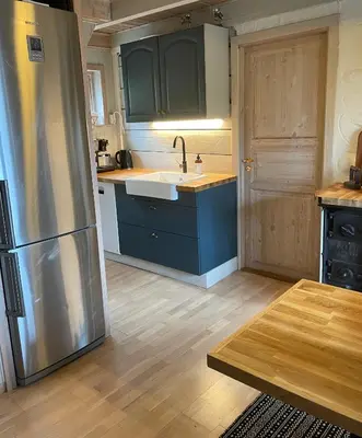 a kitchen with a sink and a refrigerator at Secluded Holiday Home, With private beach in Ålesund