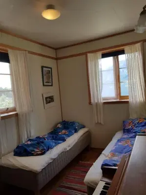 a bedroom with two beds and a piano in it at Spacious house by the Hardangerfjord in Hesthamar