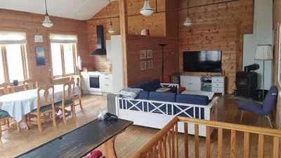 a living room with a couch and a dining room at Spacious house by the Hardangerfjord in Hesthamar