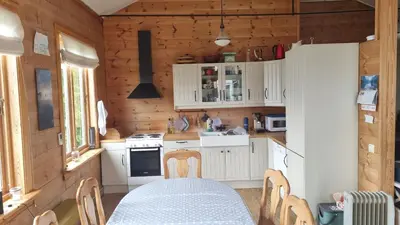 a kitchen with a table and a white refrigerator at Spacious house by the Hardangerfjord in Hesthamar